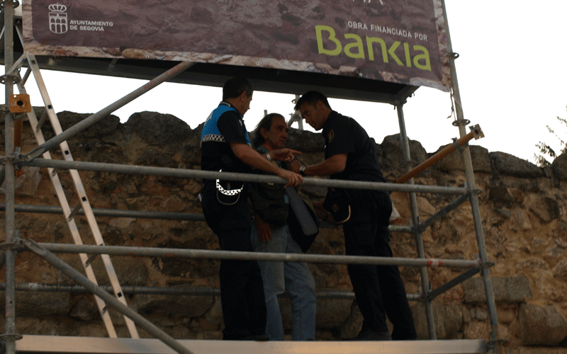El presunto suicida, ayudado por los policías para bajar del andamio.