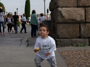 Un niño come el bocadillo entregado tras el recorrido a los pies del Acueducto.