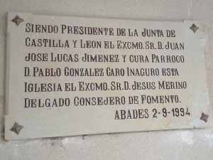 Una placa con nombres de políticos en la puerta de la iglesia de Abades.