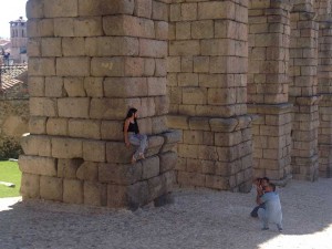 Una turista posa para una fotografía encaramada al Acueducto.