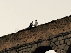 El policía charla con el hombre, en lo alto del acueducto.