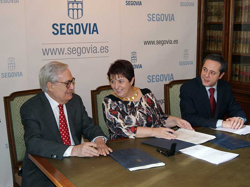 Luis Solana y Clara Luquero, observados por José Bayón, durante la firma del convenio.